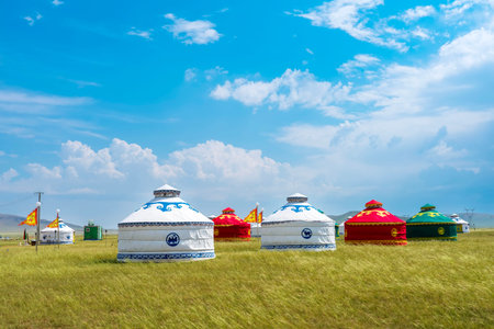 The yurt is under the blue sky and white clouds, yurts in the beautiful grassland, Mongolian yurt on...