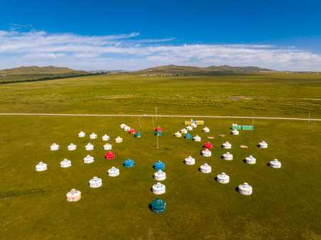 The yurt is under the blue sky and white clouds, yurts in the beautiful grassland, Mongolian yurt on the grassland. Drone aerial photographyの写真素材
