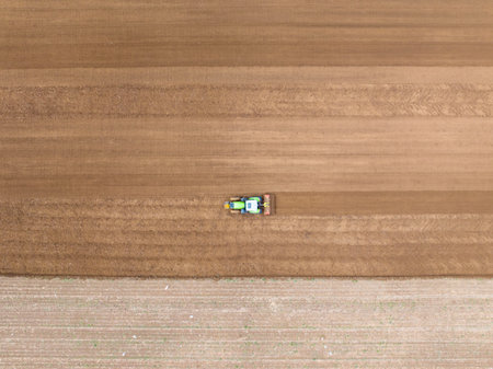 In spring, farmers use farm machinery to cultivate fields. Farmers use tractors to cultivate fieldsの写真素材