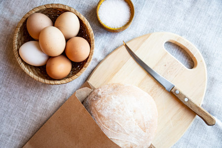 Still life bread eggs salt and milk on wooden plates on a background in warm colors