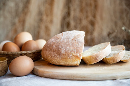 Still life bread eggs salt and milk on wooden plates on a background in warm colors
