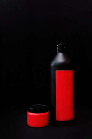 Black and red bubbles with cosmetic product on a black background. Shampoo, shower gel, soap, or body lotionの写真素材