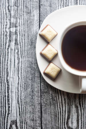 White cup with coffee on a white saucer on a gray wood backgroundの写真素材