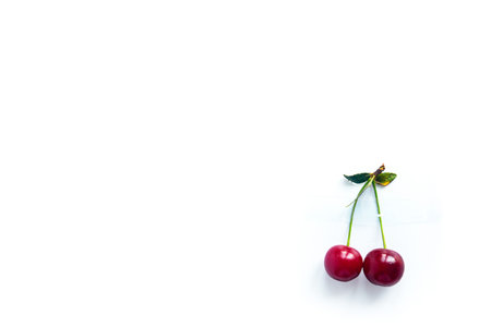 Cherry berries with cuttings glued with tape to a white background