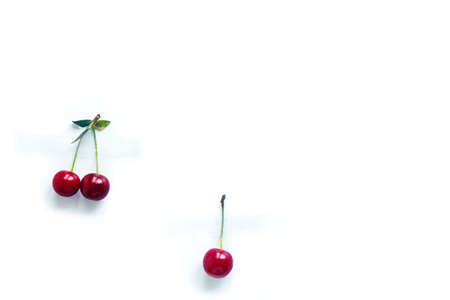 Cherry berries with cuttings glued with tape to a white backgroundの写真素材