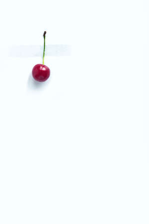 Cherry berry with cuttings glued with tape to a white backgroundの写真素材