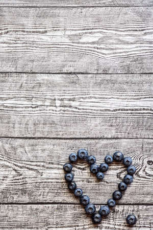 Heart made of blueberries on wooden table. top viewの写真素材