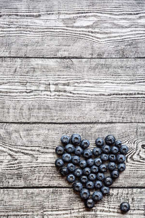 Heart made of blueberries on wooden table. top viewの写真素材