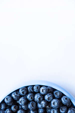 Blueberries in blue bowl on the white background. top viewの写真素材