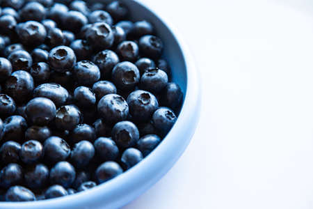 Blueberries in blue bowl on the white background. top viewの写真素材