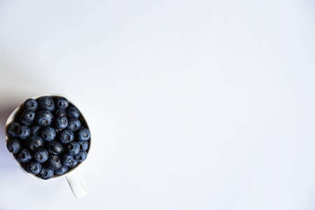 Blueberries in white cup on the white background. top viewの写真素材