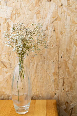 Dried flowers in a glass vase on a wooden background. warm colors.の写真素材