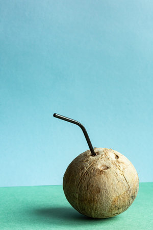 Coconut with a straw on a green-blue background with place for text. Healthy food concept.の写真素材