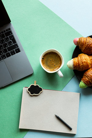 Morning workplace laptop coffee croissant with copy space. Business concept in pastel colors.の写真素材