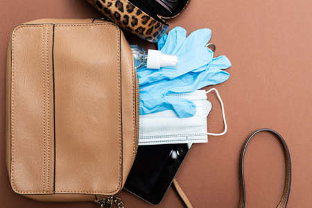 What's in a lady's bag in 2020? Protective face mask, sanitizer, gloves and tablet. Health care conceptの写真素材