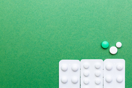 Various pills on the green background with copy space. Healthycare and Medicine concept