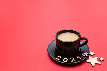 Christmas composition numbers 2021 and a cup of coffee on a red background. New year 2021 and...