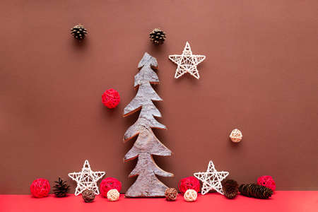 Christmas composition with wooden Christmas tree pine cones stars on a red background. Christmas card copy spaceの写真素材