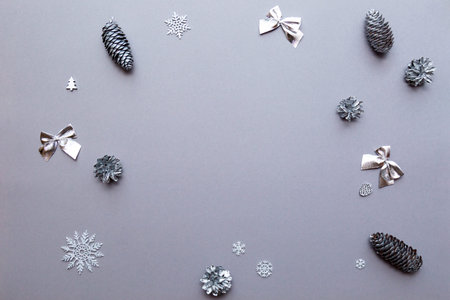 Christmas and New Year concept festive composition silver cones, bows, Christmas balls and snowflakes on gray background copy spaceの写真素材