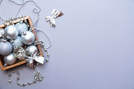 Silver Christmas decorations in a wooden box on a gray background. New Year or Christmas composition with space for textの写真素材