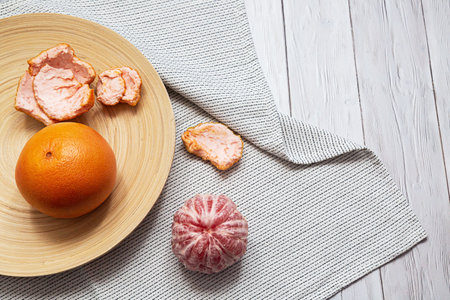 Grapefruit whole and peeled. Minimalistic flat lay on a light background with copy space. Healthy food conceptの写真素材