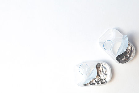 Open case with contact lenses on white background with copy space