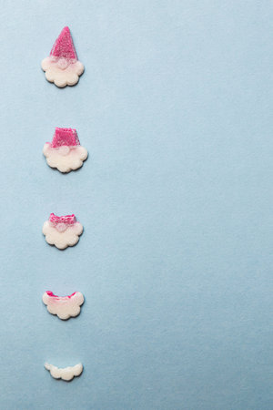 Sweets in the form of Santa Claus on a light blue background. Gnome-shaped gummies. Flat layの写真素材
