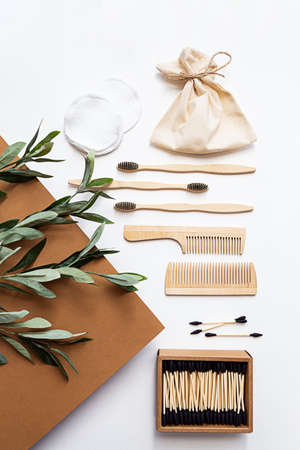 Eco friendly lifestyle concept. Modern still life scene with olive branch, zero waste products for the home. Bamboo toothbrushes and ear sticks, reusable cotton sponges and wooden combs.の写真素材
