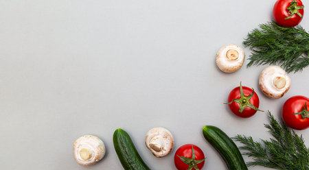 Fresh organic vegetables flat lay on gray background. Tomatoes, cucumbers, mushrooms and dill for a healthy diet. Vegan food background with copy space.の写真素材