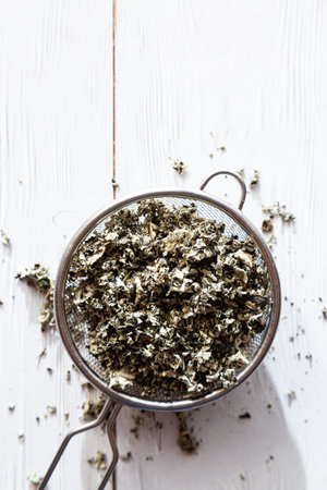 Dry raspberry leaves in a tea strainer close-up. Alternative herbal medicine. Healthy lifestyle...