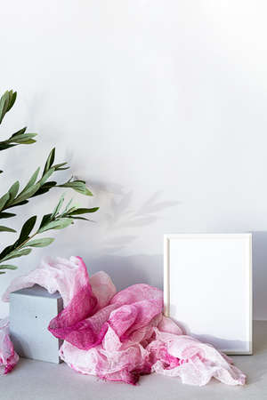 Mock-up poster white frame in modern interior. Minimal composition with a white photo frame and bright fabric, in a Scandinavian interior.の写真素材