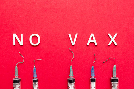 The phrase "NO VAX", broken injection syringes on a red background. Stop vaccination concept. Coronavirus Anti Vax controversy concept.の写真素材