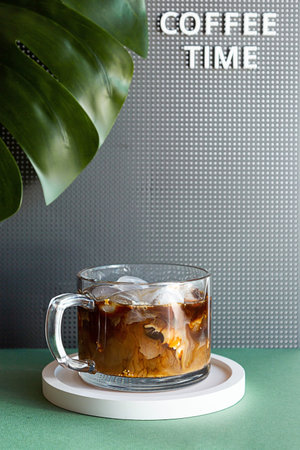 Summer composition of iced coffee cup with marshmallows. Coffee Time word and monstera palm leaf...