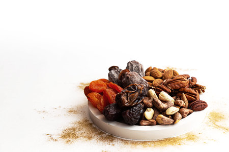 Various nuts and dried fruits, on a white-gold background. Vegan and vegetarian concept, healthy...
