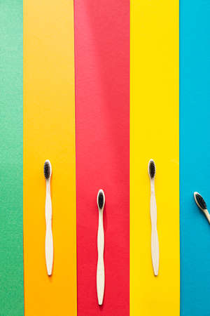 Composition of organic bamboo toothbrushes on the bright multi colored background. Natural oral hygiene. Zero waste dental protection.の写真素材