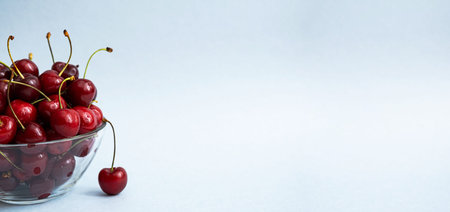 Ripe cherries in glass bowl. Juicy red cherry on a transparent plate. Copy space