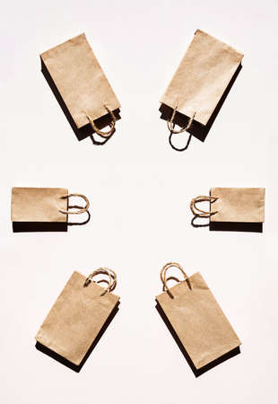 Recycled paper craft shopping bags, flat lay on light background, copy space. Sales or shopping concept.の写真素材
