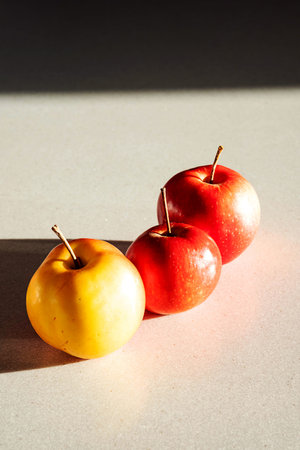 Ripe red apples on stone table. Still life in sun lighting, healthy snack, minimalism.の写真素材