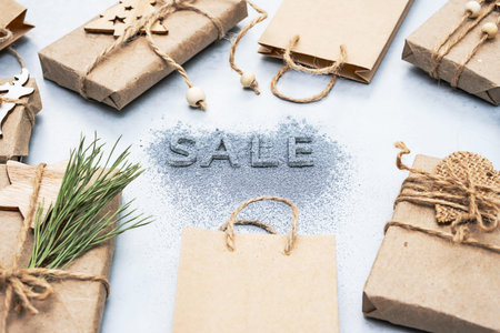 Inscription - Sale, gift boxes and brown paper bags, flat lay, copy space. Winter holiday or...