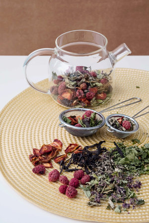 Natural herbal tea and dry berry in tea strainer. Composition with organic, dried tea leaves and...