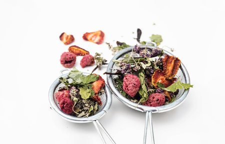 Dried tea leaves and berries in tea strainer. Composition with organic, natural herbal tea and dry...