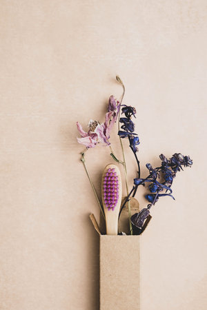 Zero waste bamboo toothbrush with dried flowers. Wooden personal dental care accessory. Plastic free, eco friendly, sustainable lifestyle concept.の写真素材