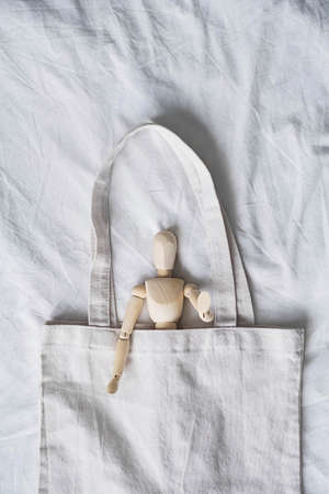 Reusable shopping bag with wooden puppet, rejection of plastic.  Caring for the environment, zero waste, sustainable lifestyle.の写真素材