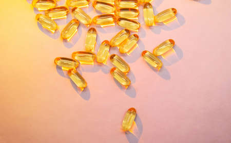 Omega 3 fish oil with EPA, DHA capsules on pastel pink background. Dietary supplement supports heart health.の写真素材
