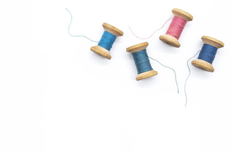 Colorful threads for sewing. Different threads on wooden vintage reels.