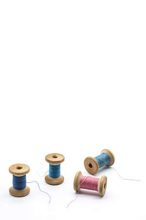 Colorful threads for sewing. Different threads on wooden vintage reels.の写真素材
