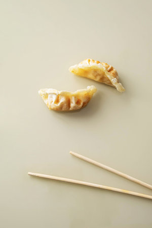 Fried gyoza dumpling and bamboo chopsticks, minimal style. Asian food.の写真素材