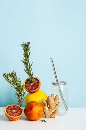Tropical drink still life. Creative scene with flavored water in drink can citrus fruits, rosemary and ginger.の写真素材