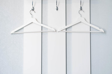 Empty clothes hanger. Wooden white hangers on white wooden wardrobe.の写真素材