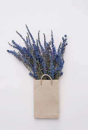 Paper shopping bag with dried flowers bouquet. Autumn gift sales concept.の写真素材